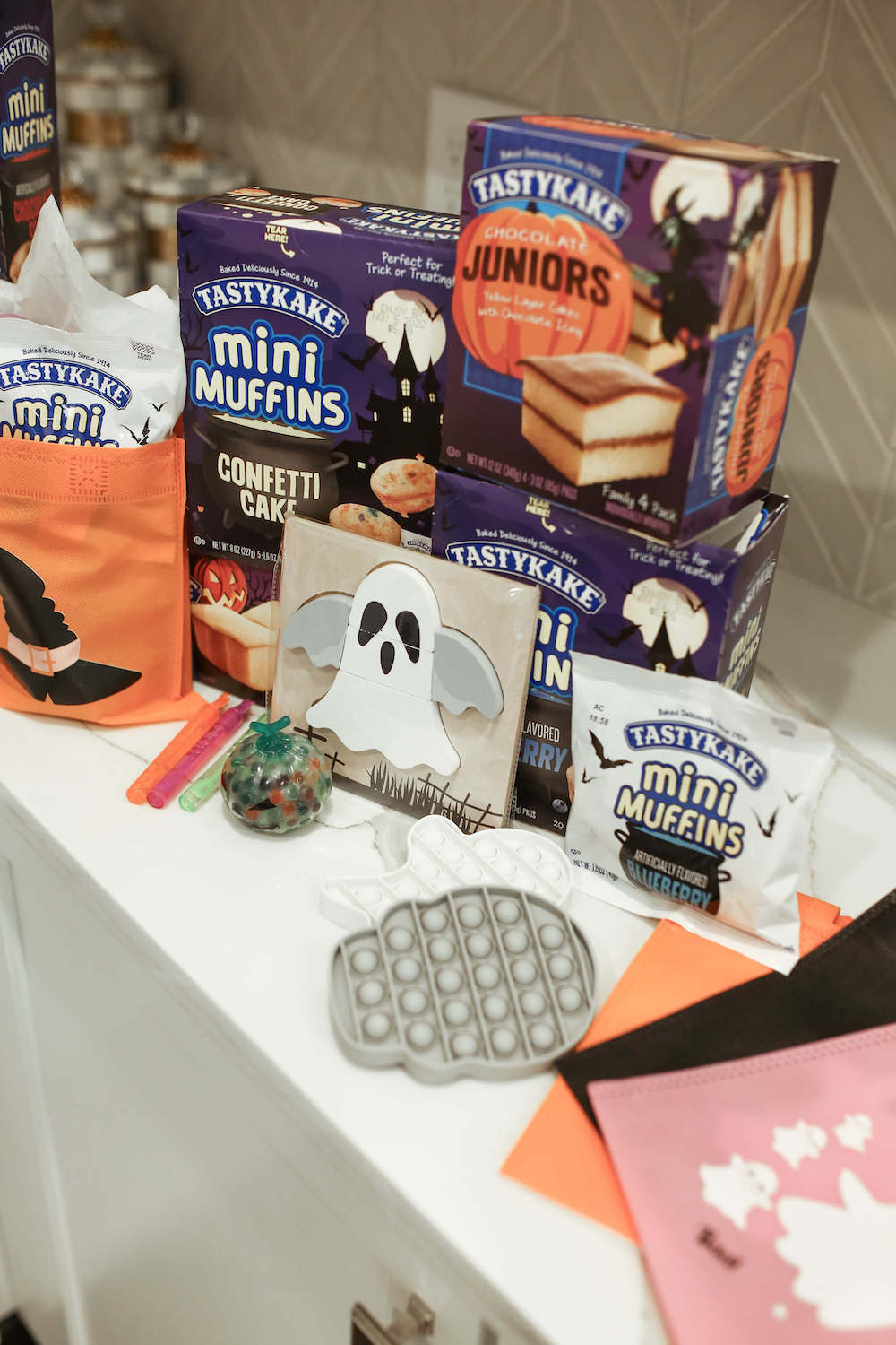 tastykake and gray popit toys sitting on counter to put in boo bags